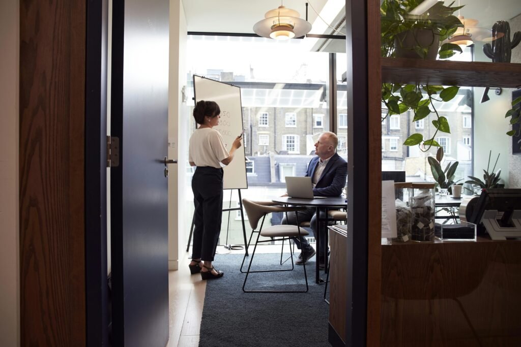 pexels-photo-2977547-2977547 Colleagues engage in a strategic business meeting in a contemporary London office with city views.